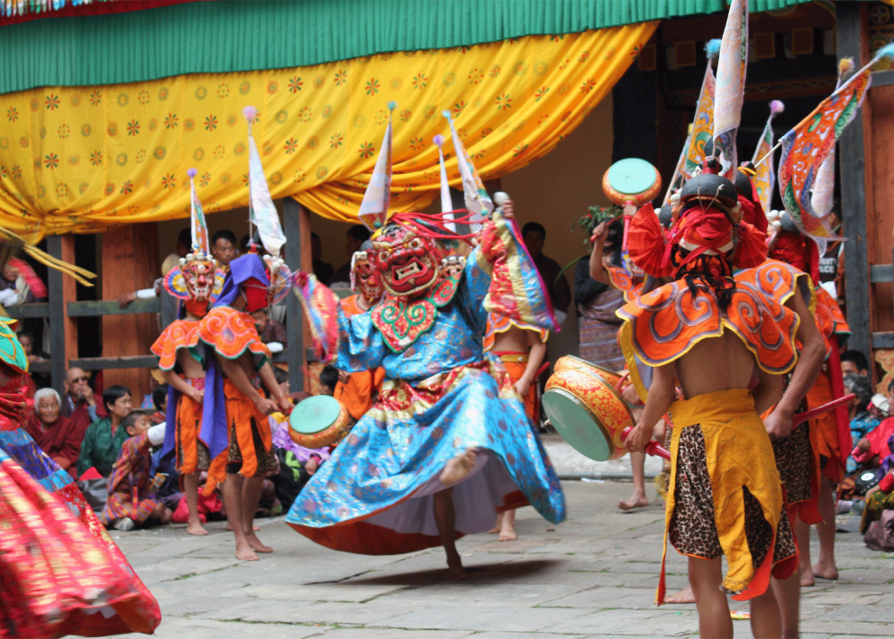 Performers in colorful costumes and masks dance at the Sage Dawa festival in Tibet.